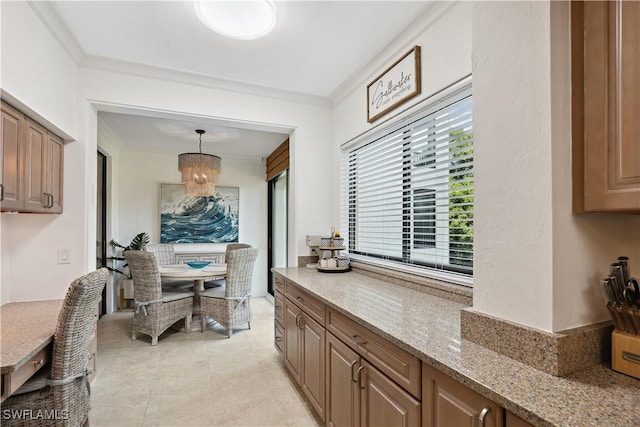 interior space with decorative light fixtures, ornamental molding, light stone counters, and a notable chandelier