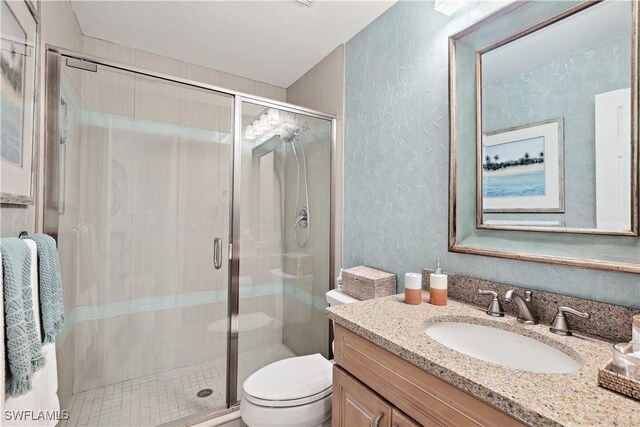 full bath with vanity, toilet, and a stall shower