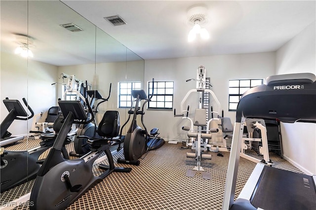 exercise room featuring carpet floors, visible vents, and baseboards