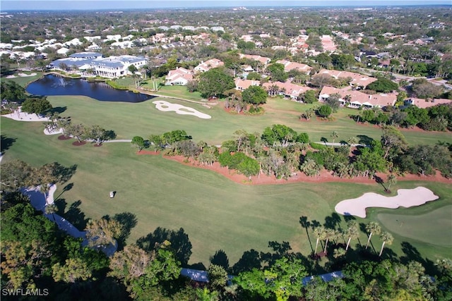 drone / aerial view with view of golf course and a water view