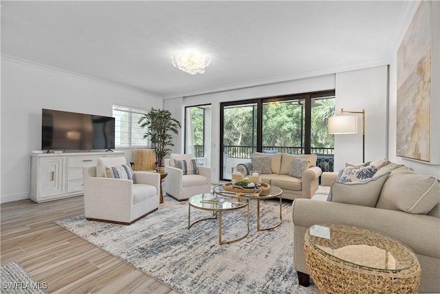 living room with baseboards, ornamental molding, and wood finished floors