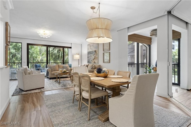 dining space with light wood-style flooring and baseboards