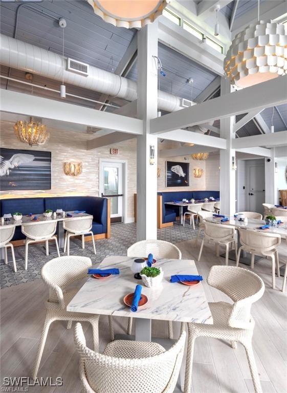 6510 Valen Way Unit B102, Naples, FL 34108 - dining space with wood finished floors and a towering ceiling