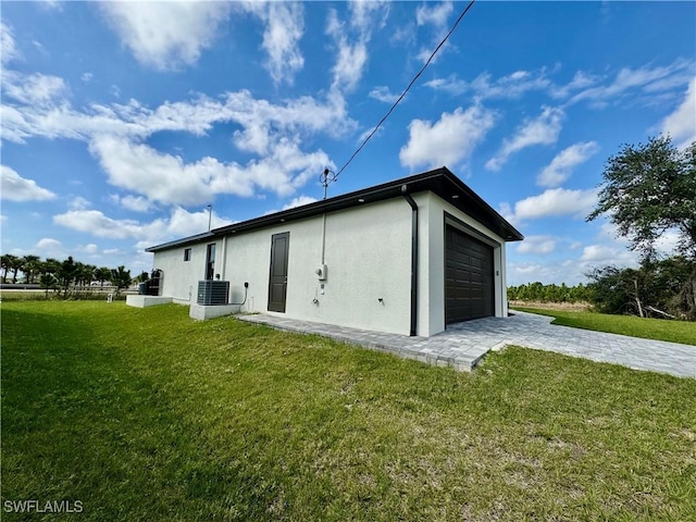 back of house with a yard, cooling unit, and stucco siding