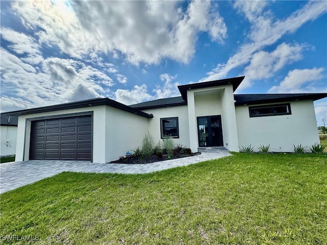 view of front of house with a garage, a front lawn, decorative driveway, and stucco siding