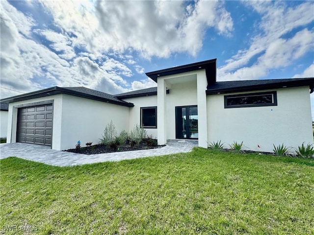 view of front of house featuring a garage, a front yard, decorative driveway, and stucco siding