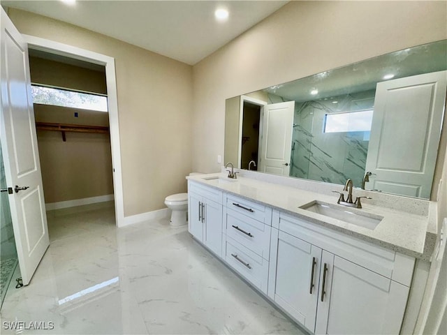 full bathroom featuring marble finish floor, a marble finish shower, baseboards, and a sink