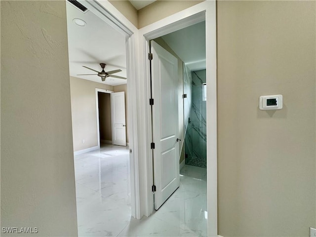 hallway featuring marble finish floor, baseboards, and visible vents