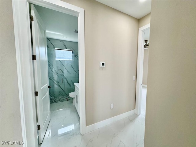 hall featuring marble finish floor and baseboards