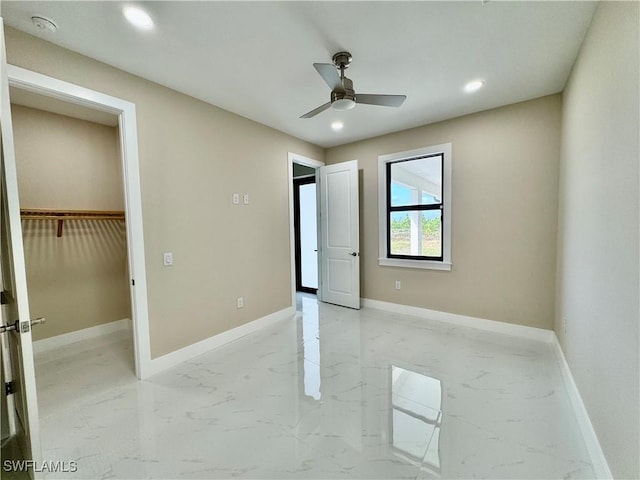 unfurnished bedroom with marble finish floor and baseboards