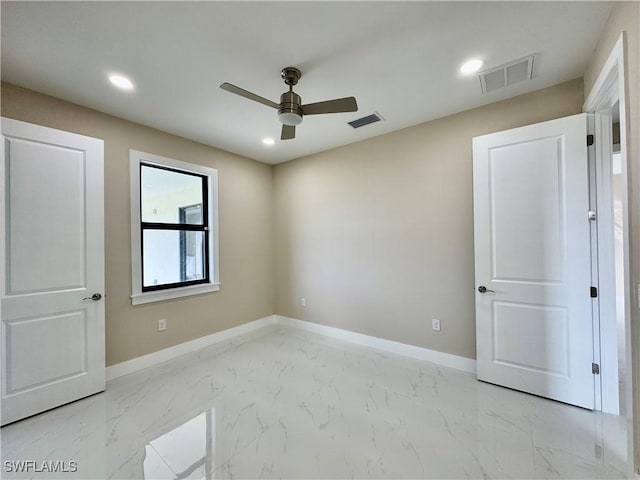 empty room with marble finish floor, baseboards, visible vents, and recessed lighting