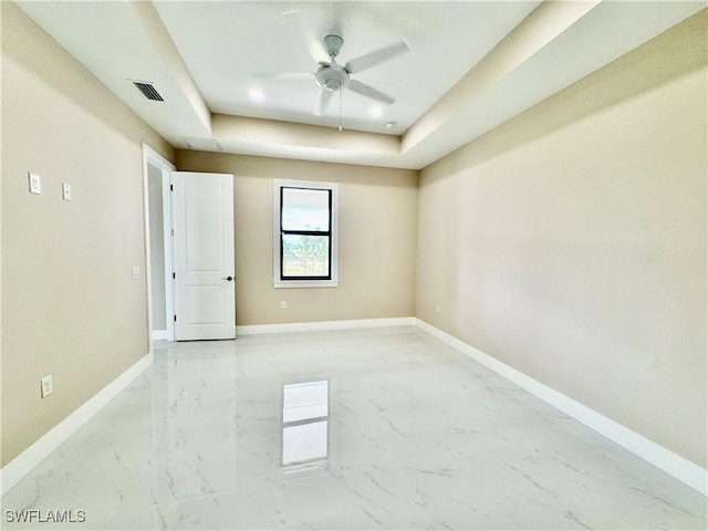 empty room with marble finish floor, a ceiling fan, visible vents, and baseboards