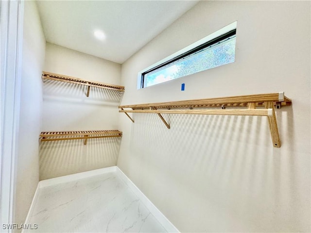 walk in closet with marble finish floor