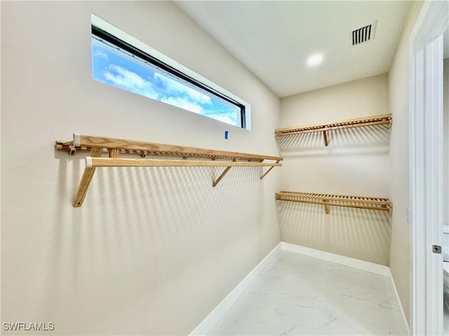 walk in closet featuring marble finish floor and visible vents