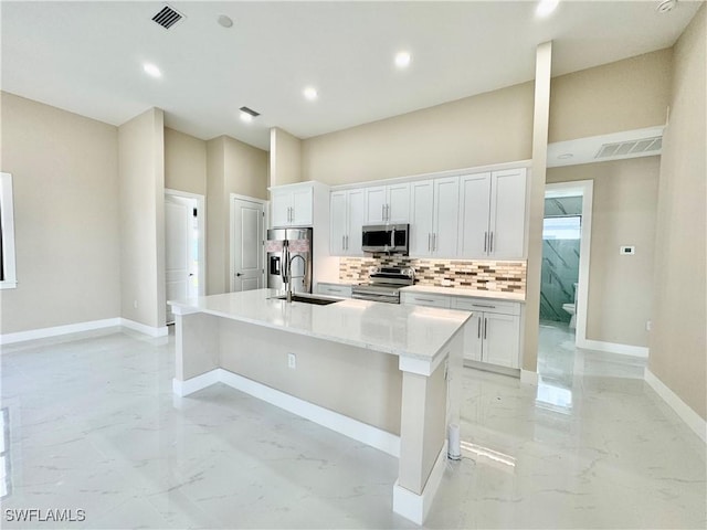 kitchen featuring stainless steel appliances, marble finish floor, visible vents, and a center island with sink