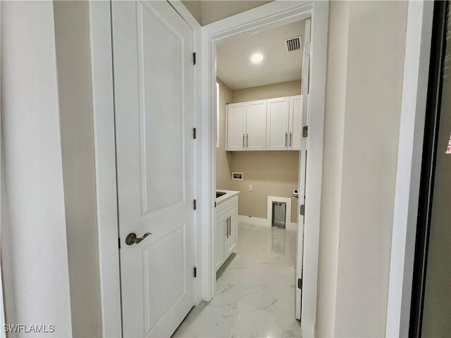 clothes washing area with washer hookup, marble finish floor, cabinet space, and visible vents