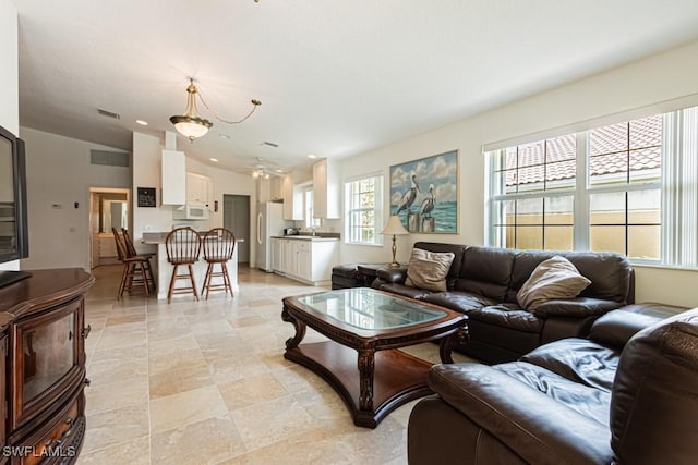 living area with visible vents and lofted ceiling