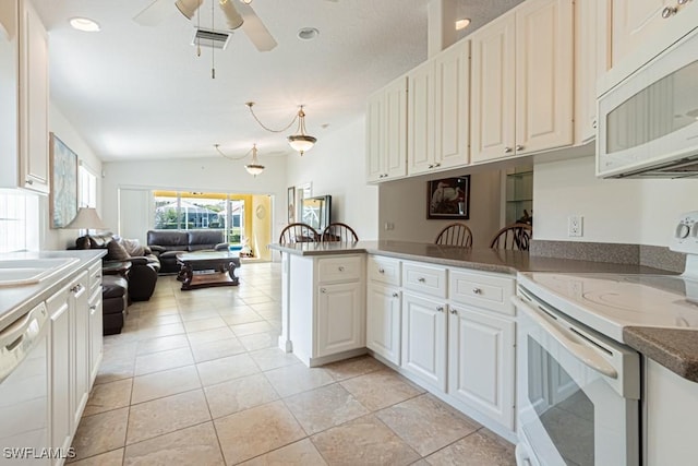 kitchen with visible vents, open floor plan, white appliances, a peninsula, and lofted ceiling