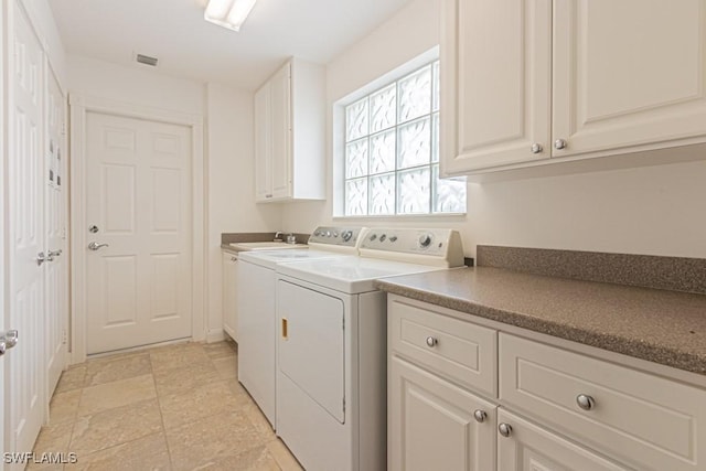 washroom featuring cabinet space, visible vents, independent washer and dryer, and a sink