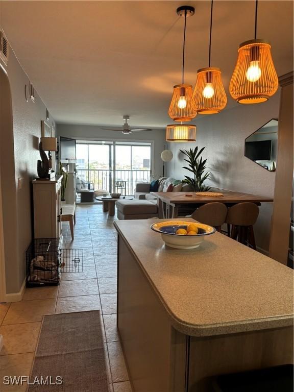 kitchen with open floor plan, pendant lighting, baseboards, and ceiling fan