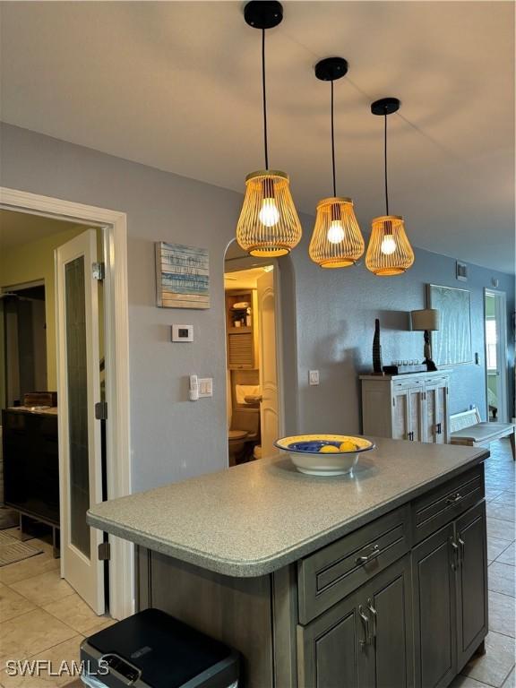 kitchen with hanging light fixtures, light countertops, open floor plan, and a kitchen island