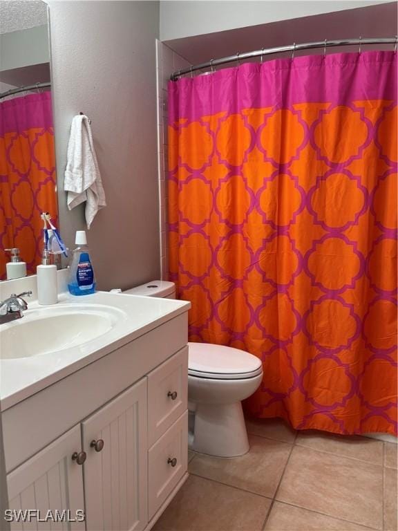 full bath with toilet, a textured ceiling, tile patterned flooring, and vanity