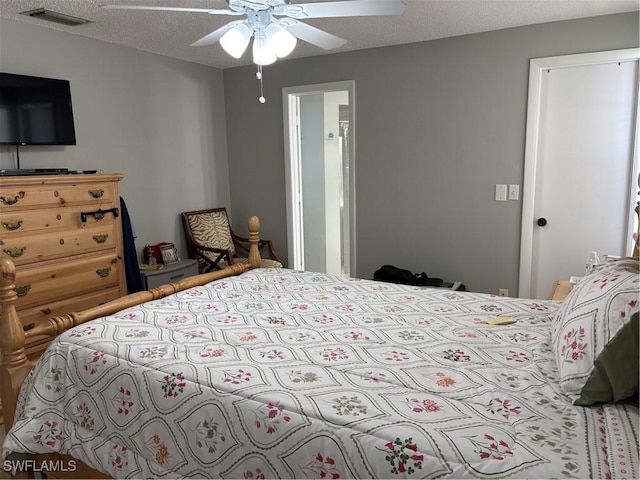 bedroom featuring a textured ceiling, visible vents, and a ceiling fan