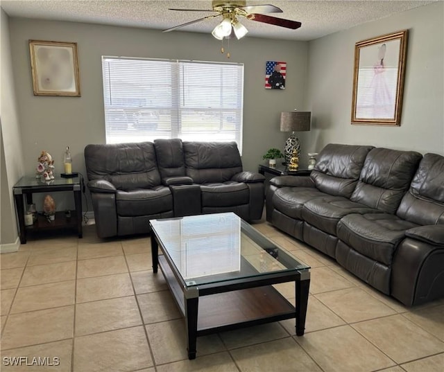 living area featuring light tile patterned floors, a ceiling fan, and a textured ceiling