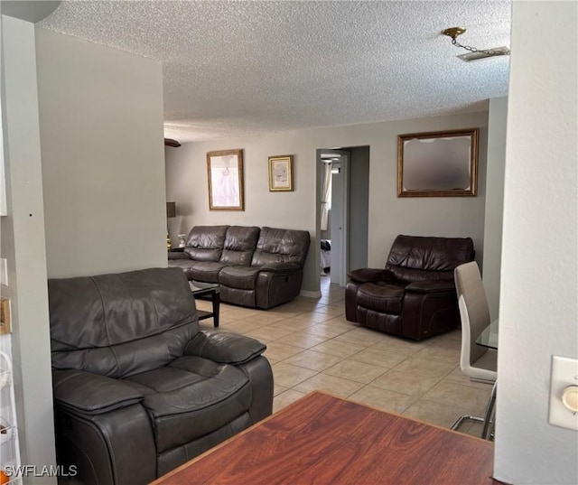 living room featuring a textured ceiling and light tile patterned floors