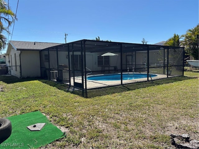 outdoor pool featuring a yard, fence, and a lanai