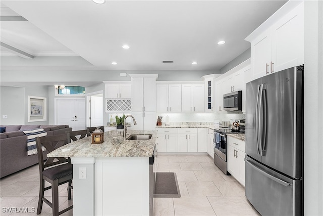 1702 SE 1st Ter, Cape Coral, FL 33990 - kitchen with appliances with stainless steel finishes, a breakfast bar, open floor plan, a sink, and backsplash