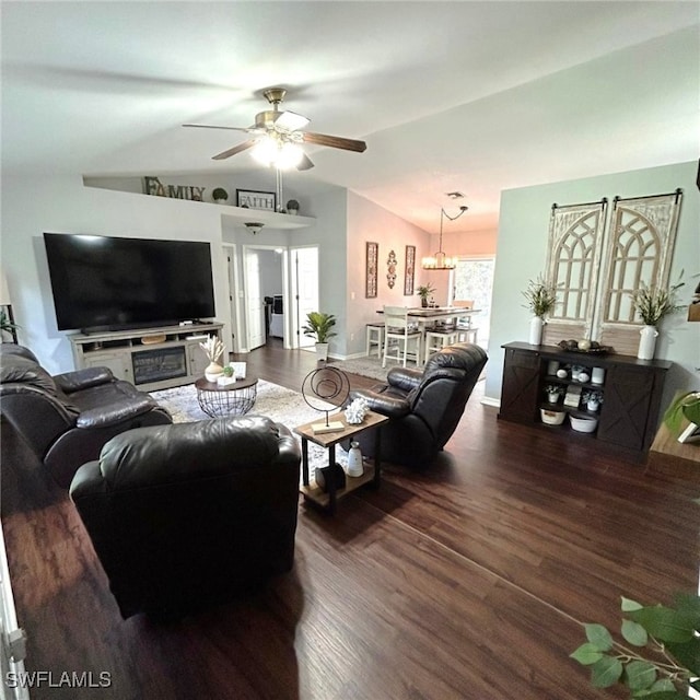 living room featuring a ceiling fan, vaulted ceiling, baseboards, and wood finished floors