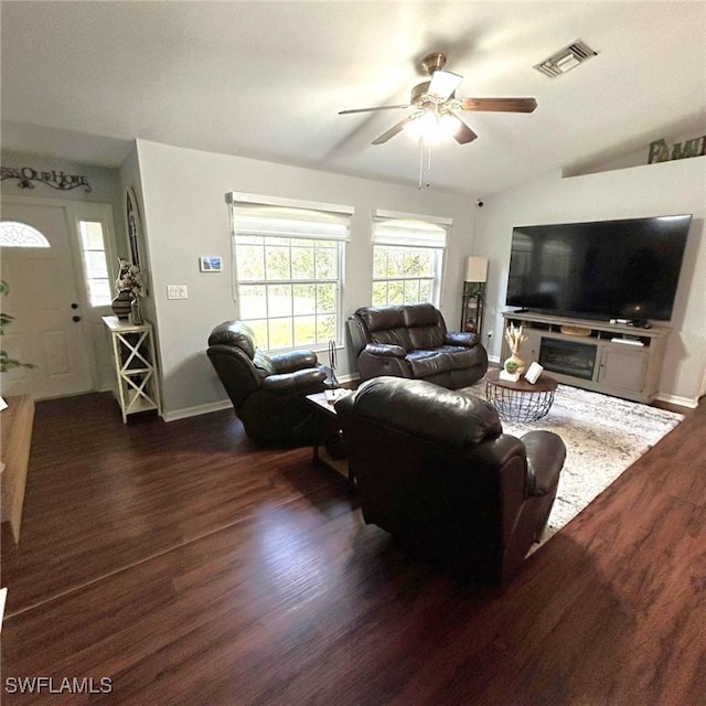 living room with visible vents, dark wood finished floors, baseboards, and ceiling fan