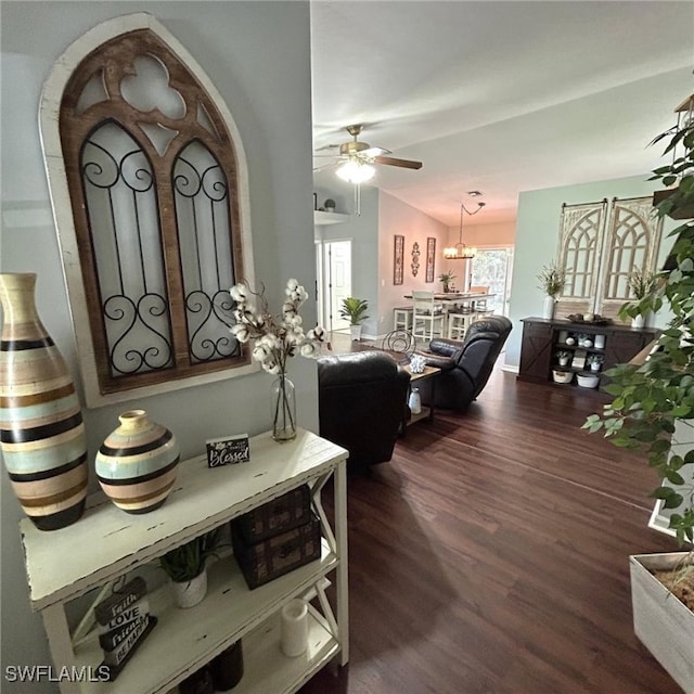 living area with vaulted ceiling, wood finished floors, and a ceiling fan