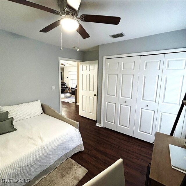 bedroom with ceiling fan, a closet, wood finished floors, and visible vents