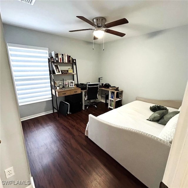 bedroom featuring dark wood-style flooring, a ceiling fan, and baseboards