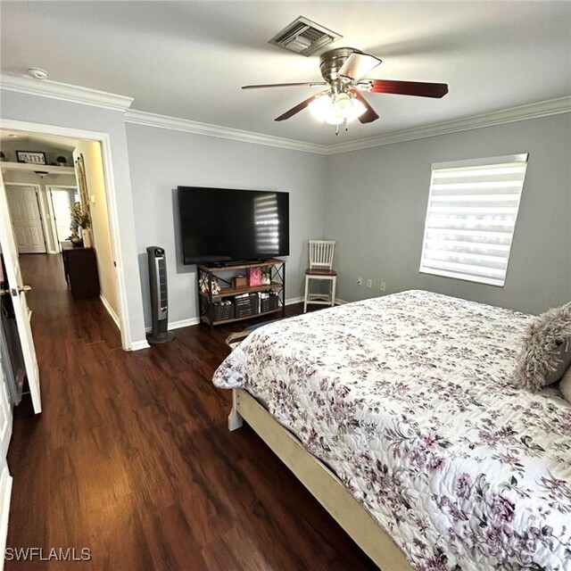 bedroom featuring visible vents, crown molding, baseboards, and wood finished floors