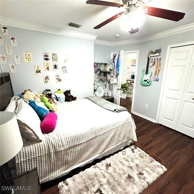 bedroom with baseboards, visible vents, ceiling fan, wood finished floors, and crown molding