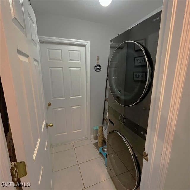 laundry area featuring light tile patterned floors, laundry area, and stacked washer and clothes dryer