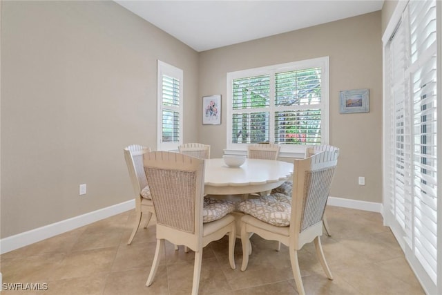 dining room featuring baseboards and light tile patterned floors