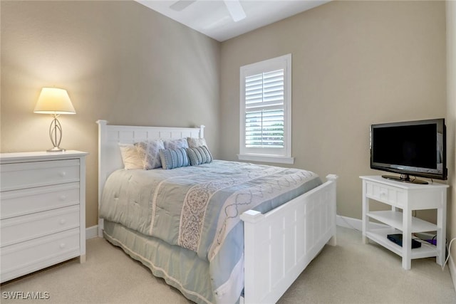 bedroom featuring light carpet, a ceiling fan, and baseboards