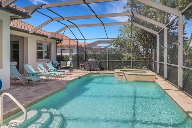 outdoor pool featuring glass enclosure, a patio area, a grill, and an in ground hot tub