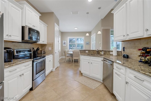 kitchen with appliances with stainless steel finishes, white cabinetry, and a sink