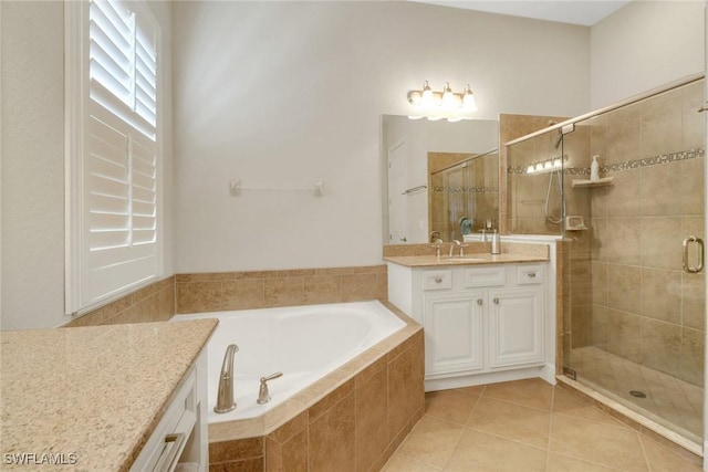 full bathroom featuring a garden tub, a shower stall, vanity, and tile patterned floors