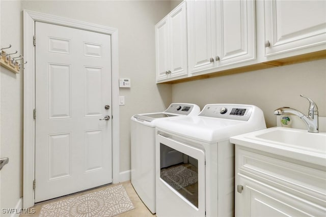 laundry room featuring light tile patterned flooring, independent washer and dryer, a sink, and cabinet space