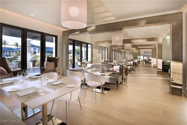 dining room featuring light wood-type flooring and a high ceiling