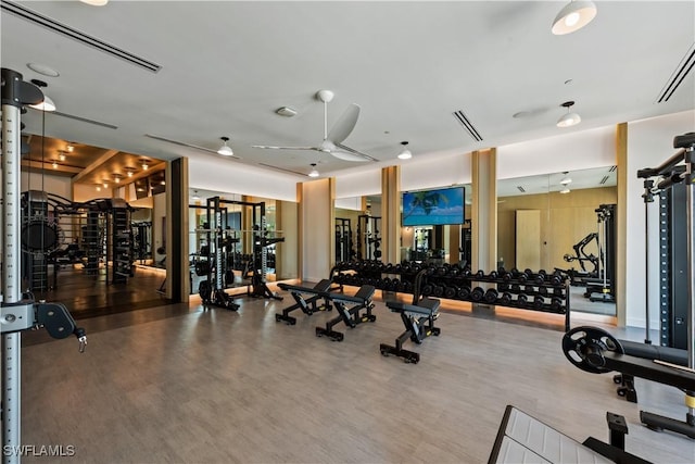 exercise room featuring a ceiling fan, visible vents, and wood finished floors