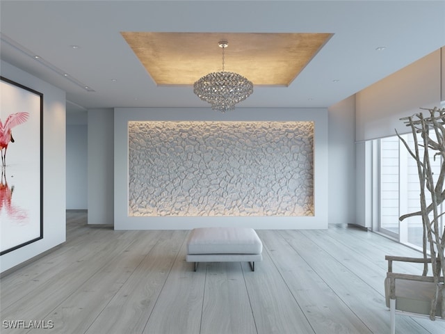 hallway featuring a chandelier, a tray ceiling, and wood finished floors