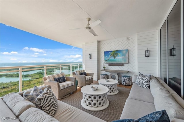 exterior space with a water view, wood finished floors, and a ceiling fan