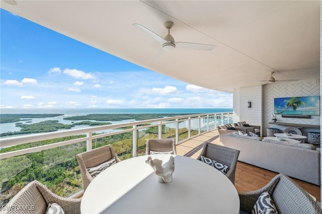 balcony with outdoor dining space, ceiling fan, and an outdoor living space